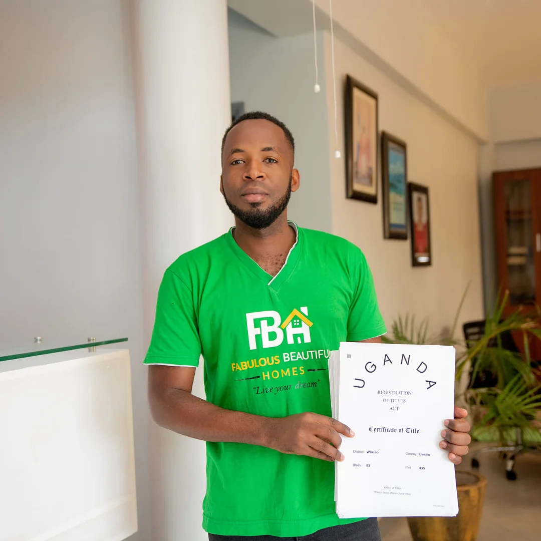 Male company staff in green shirt holding land titles.